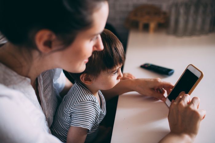 A mother and child bonding while using a smartphone at home